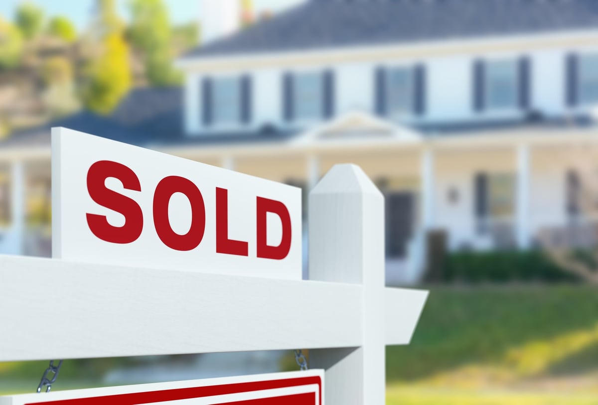 Sold sign in front of luxury home