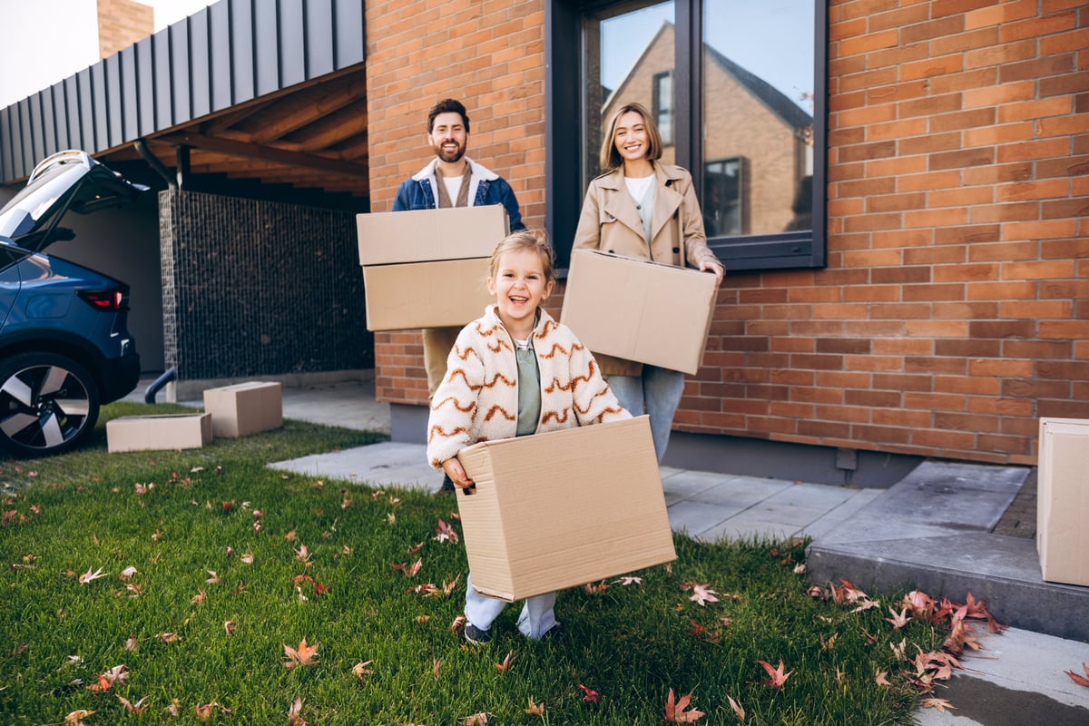 Family moving into their new Houston home, carrying boxes